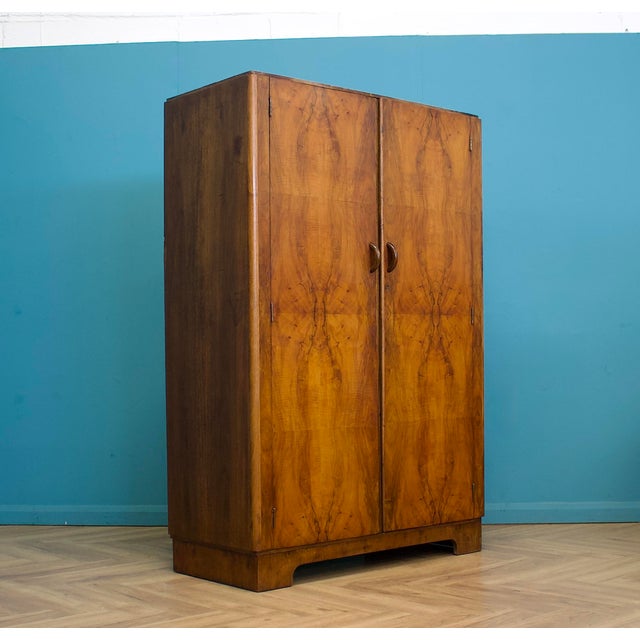 Italian Art Deco walnut wardrobe with striking bookmatched veneers, rounded corners and original curved handles, raised on...