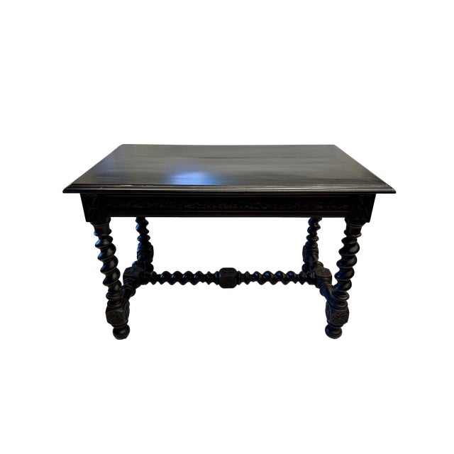 This striking 19th century Baroque Revival library table or writing desk is executed in a deep ebonized finish,...