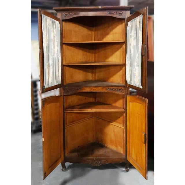 Mid Century wooden triangular corner cupboard with four doors and interior shelves. Curtain rods can easily be removed...