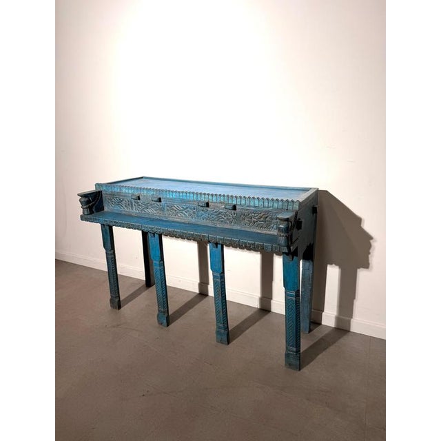 Striking Indian console table featuring beautiful hand-carved detailing and a distinctive distressed turquoise-blue...