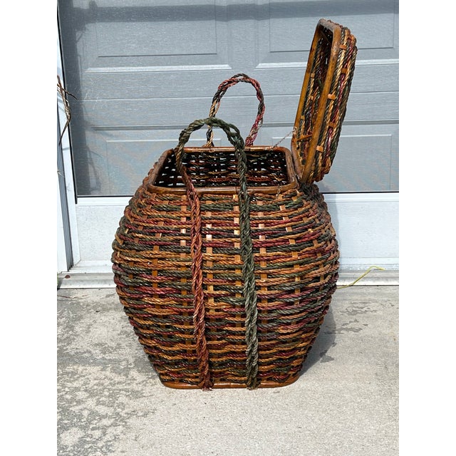Large multi color woven basket. Bamboo reed strapping with interwoven rope and wood. Bent wood framing and knotted rope...