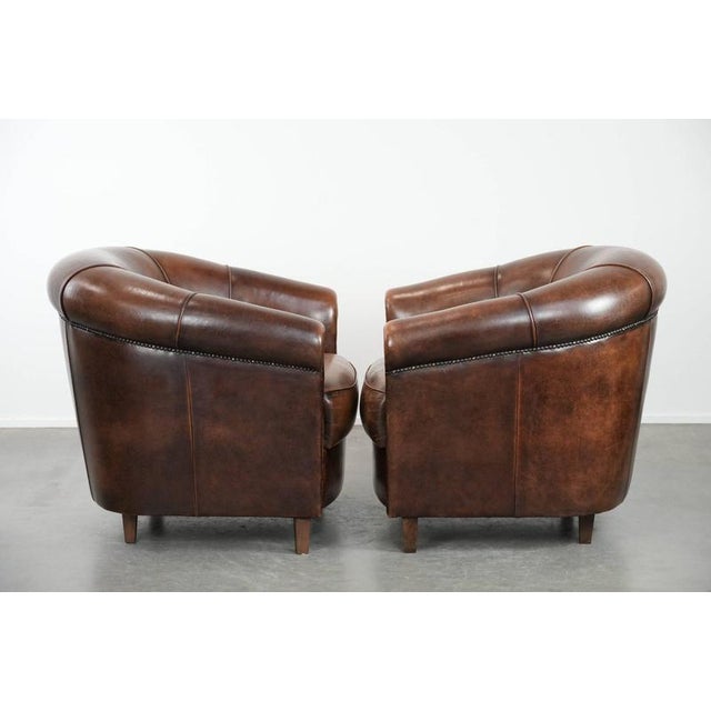 We offer this set of two desirable sheepskin club chairs with fixed seat cushions and beautiful colors. An elegant set...