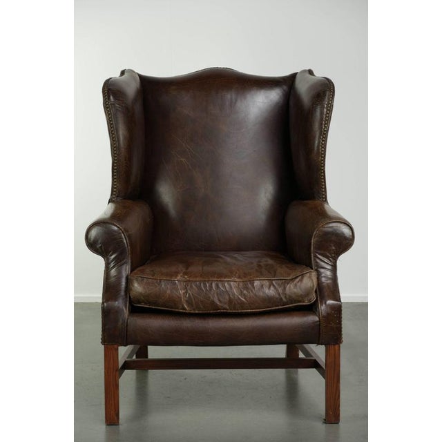 This comfortable and characterful wing armchair is made of cowhide leather and has a luxurious look. It is finished with...