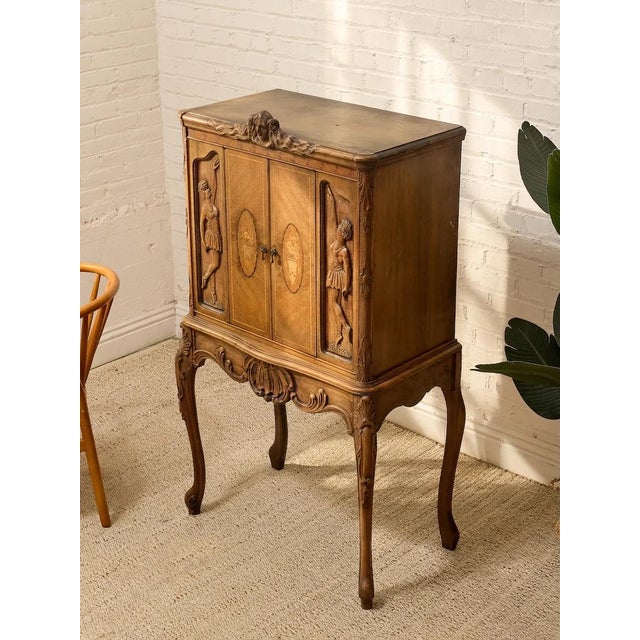 An extraordinary antique-style cabinet with elaborate carved and inlaid detailing inspired by French Louis XV and Belle...