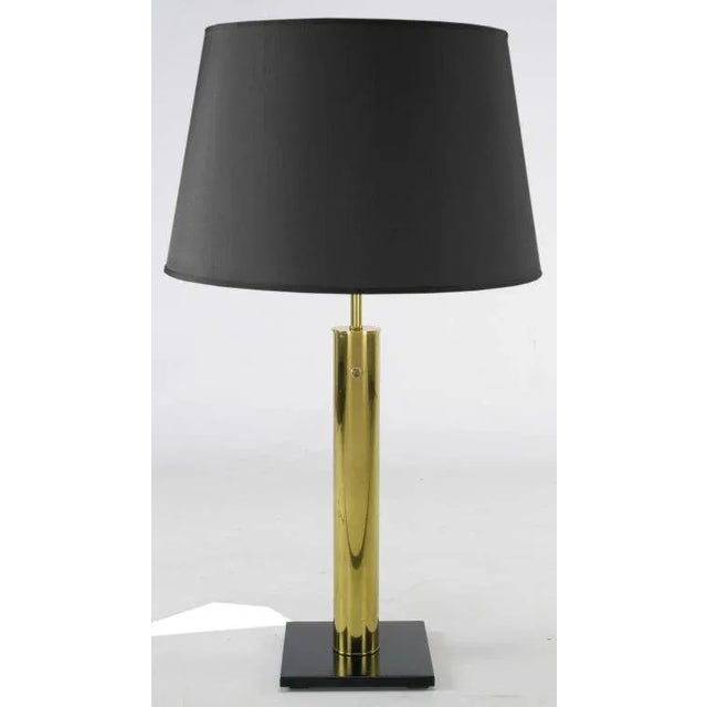 Brass cylinder table lamp with black lacquered steel base by Walter Von Nessen for Nessen Lighting. Brass stem and factory...