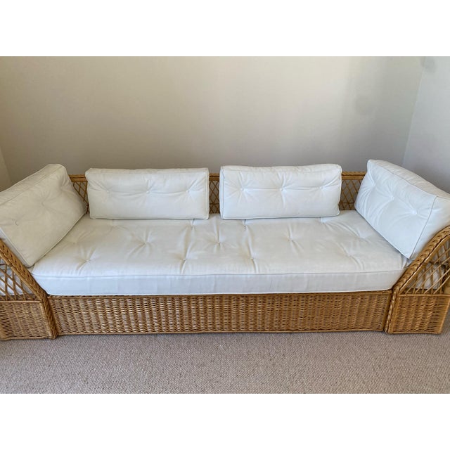 Natural wicker, rattan frame couch with white cushions from The McGuire Company, c. 1970. The white leather cushions are...
