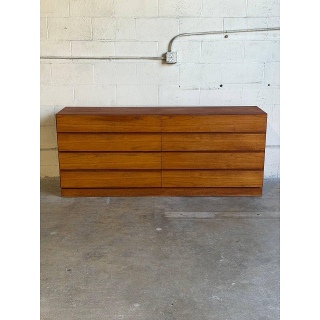 This minimalist lowboy chest of drawers features a sleek handleless front design and a plinth base. Clean geometric lines...