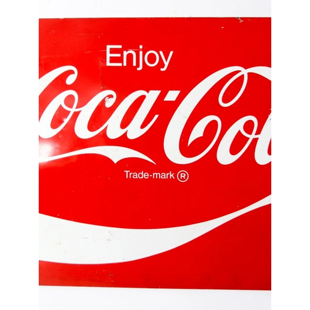 A vintage Coca-Cola ribbon logo sign, circa 1969–1985, featuring the iconic red and white colorway. bold, large-scale...