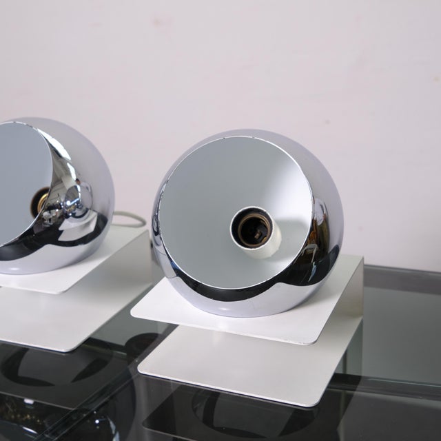 Eyeball table lamp, Italy, 1970s. White lacquered metal base and chrome-plated metal diffuser. Adjustable spherical...