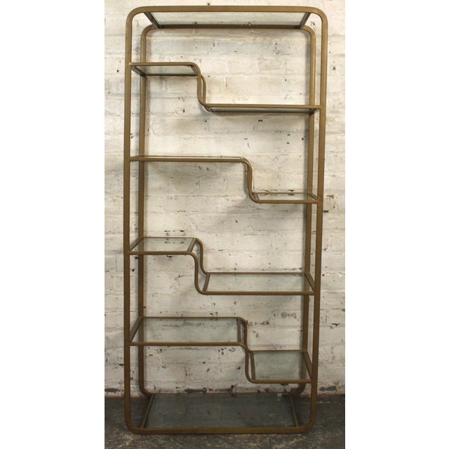 This is a multitiered glass and bronze plated shelf. The shelf stair steps in a waterfall pattern, with glass bases that...