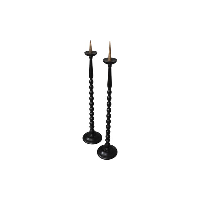 A pair of tall wood pricket floor candlestick holders circa 1900. The central columns are hand turned in a spool...