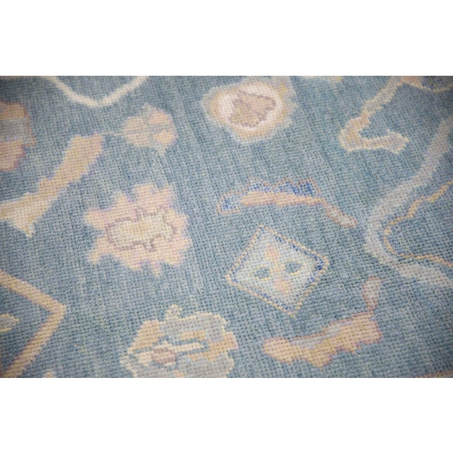 This modern Turkish Oushak rug is a stunning piece of art that has been handwoven using traditional techniques by skilled...