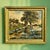 This antique oil on canvas landscape painting depicts a sunlit rural scene with a prominent tree and a field of blue...