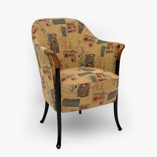 This armchair is made of solid lacquered beech and has polished Pau Ferro armrests. The seat and backrest padding is made...