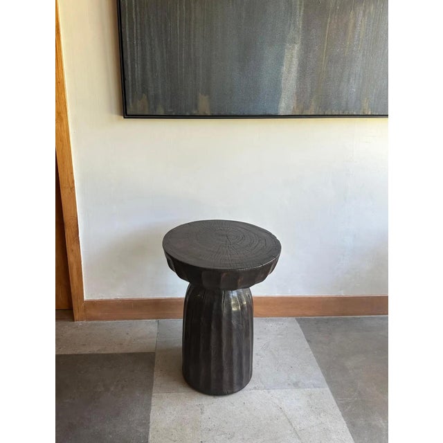 A wonderfully sculptural round side table, with an hourglass shape. Its neutral pigments make it perfect for any space. A...
