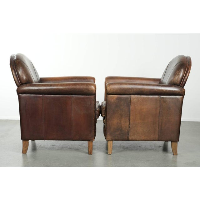 We are offering this timeless, luxurious, and characterful set of two sheepskin design armchairs with a beautiful patina....