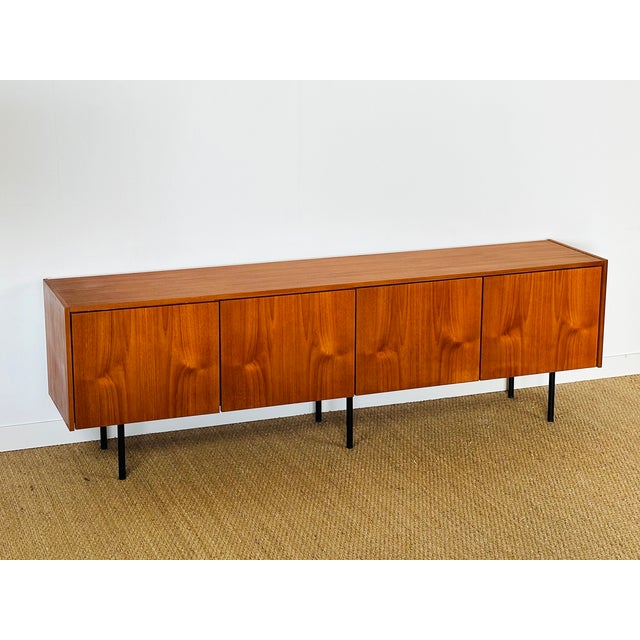 Magnificent minimalist vintage Scandinavian teak sideboard dating from the 1960s. Features four storage doors. Black metal...