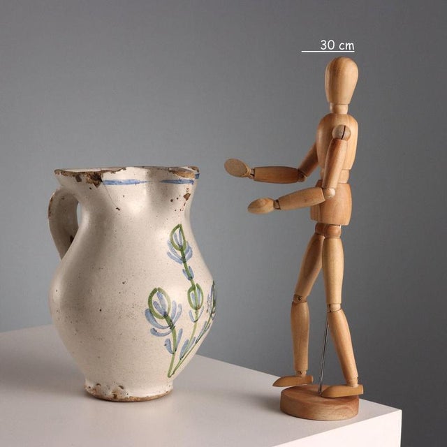 Monochrome majolica jug with a stylized decoration in shades of blue and copper green. Trilobed rim and ribbon handle....