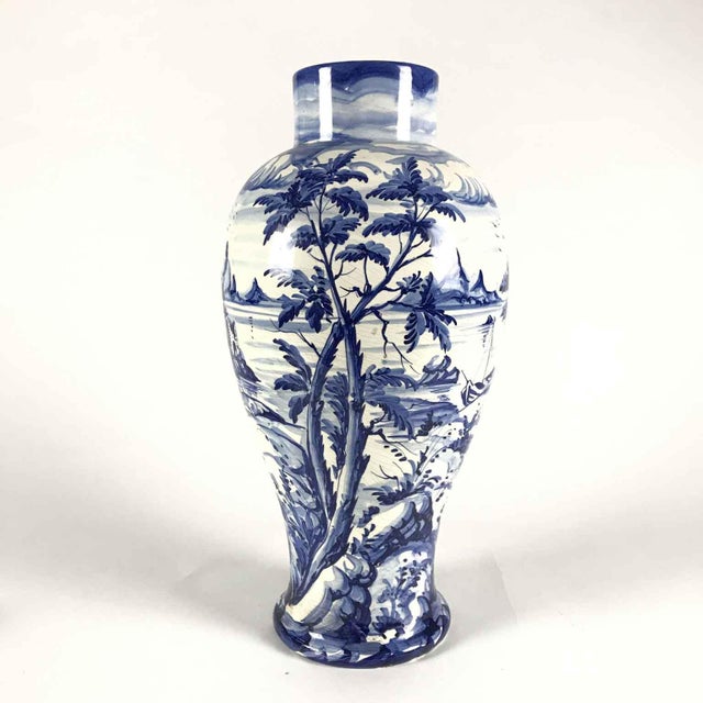 A Taccini family white and blue ceramic vase from Vinci, 1976, featuring a richly decorated lake landscape with boats, all...