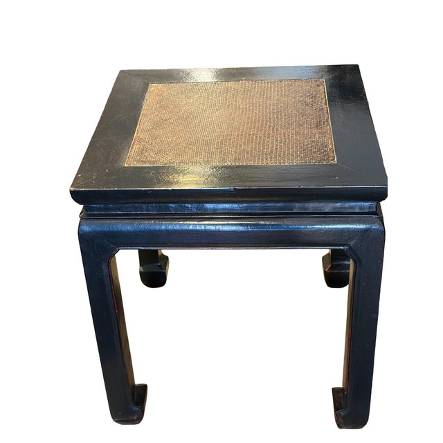 Pair of Chinoiserie-style end tables featuring dark black-lacquered wood frames, square tops with woven rattan inset...