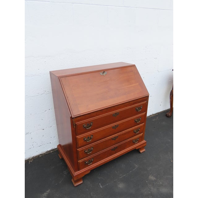 This Secretary Desk is made out of wood, solid wood, and solid cherry. It was made by Maddox furniture and it is labeled....