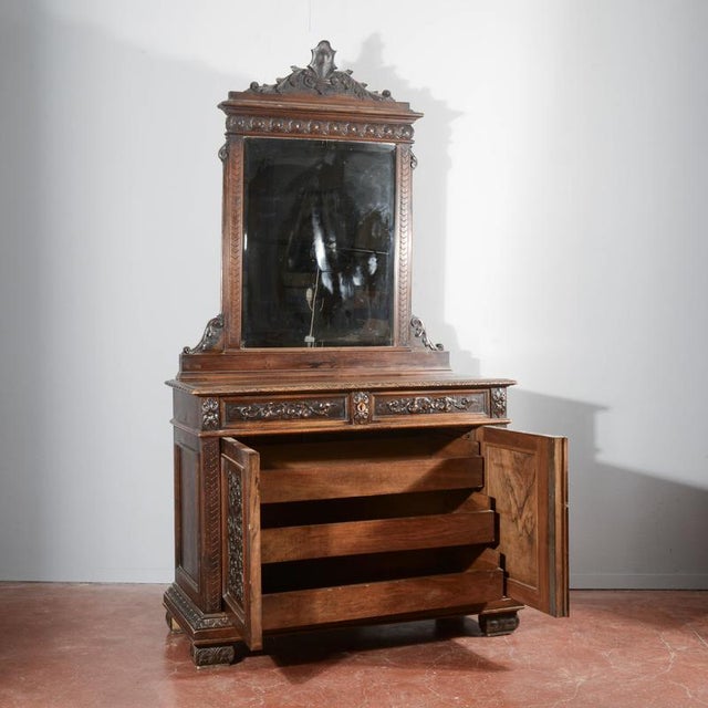 Sideboard with mirror in italian carved walnut from the late 1800s, made with solid wood parts and fur-covered parts....