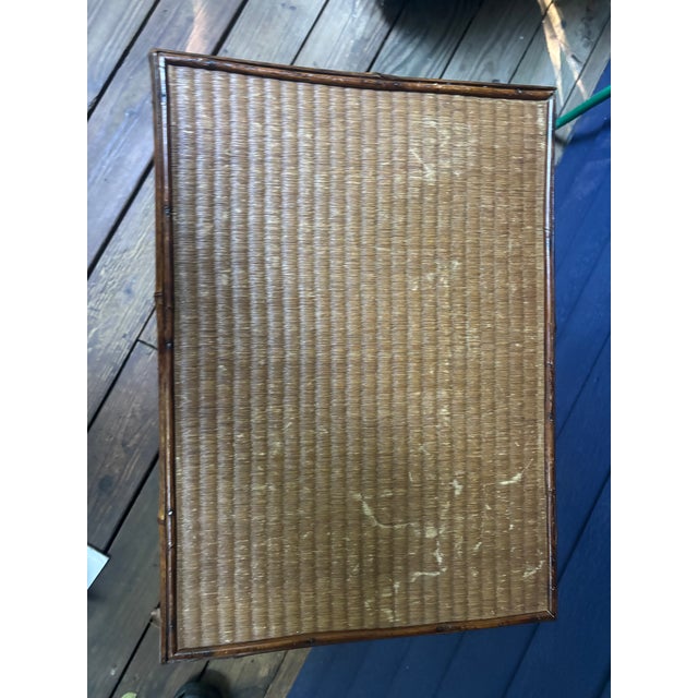 An English burnt bamboo two-tier side table with its original grass cloth, top and bottom. The grass cloth on the top has...