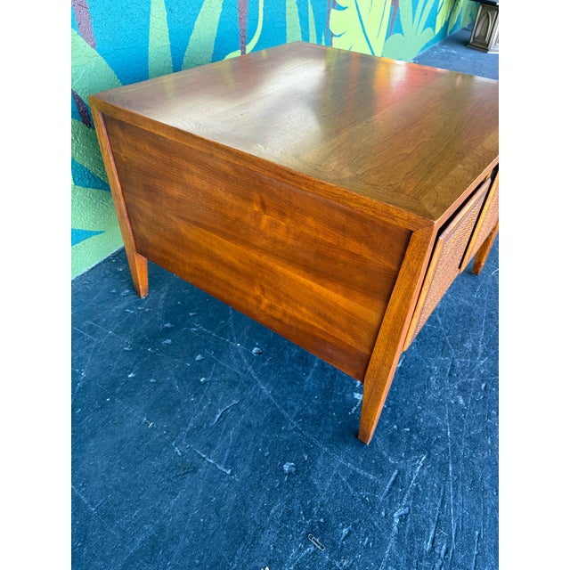 Great mid century end table with closed, cane-front storage and walnut construction