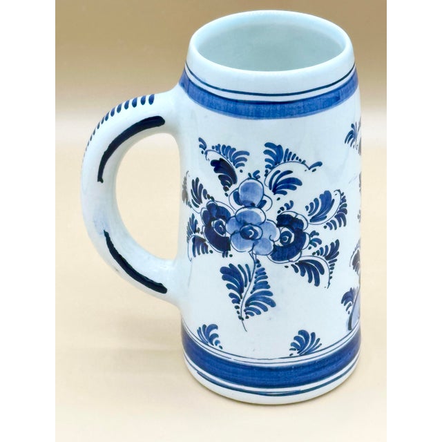 Hand-painted Dutch Delft blue and white stein featuring bold traditional floral decoration in layered cobalt tones on a...