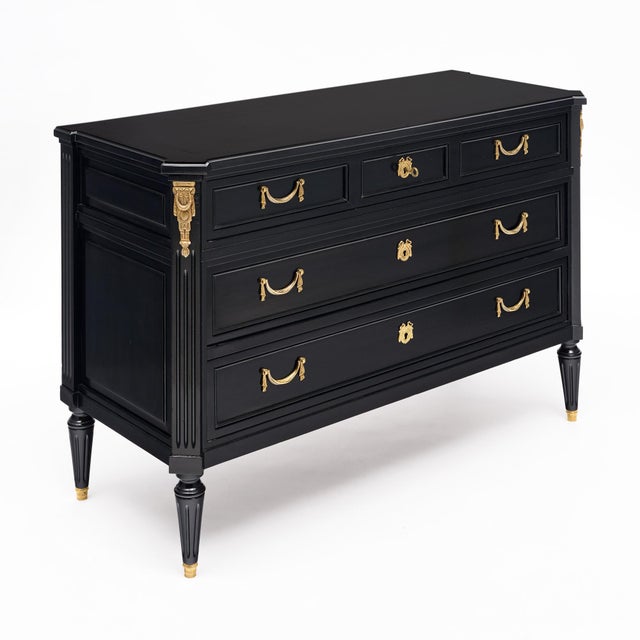 A refined French Louis XVI style commode, crafted in mahogany and finished in a lustrous black ebonized French polish. The...