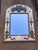 Mirror is framed beautifully with hand painted wheat bundles with flowing red ribbons. Top of mirror features purple grape...