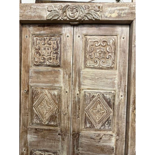 A soulful blend of artistry and heritage, this antique Indian double door features an intricately hand-carved Om symbol...