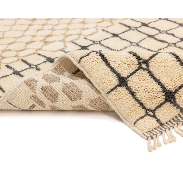 Sophisticated hand-knotted wool rug with an Ivory base, featuring abstract Taupe and Honey Ginger blocks intersected by...