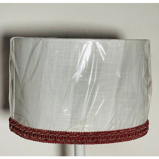 White linen lamp shade decorated with deep red gold trim.