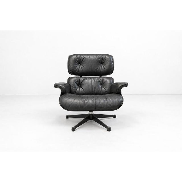 Vintage lounge chair with ottoman designed by Charles Eames and produced by Vitra. Seat and backrest with shells of...