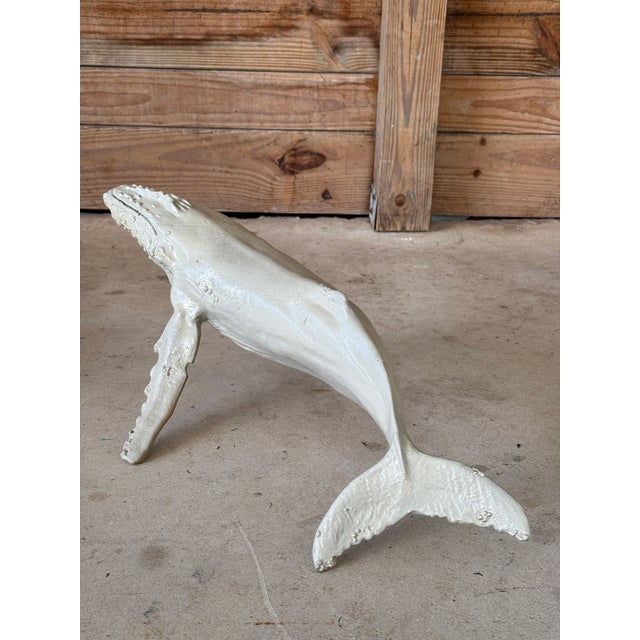 Striking vintage humpback whale sculpture crafted from cast metal and retaining remnants of its original painted finish....