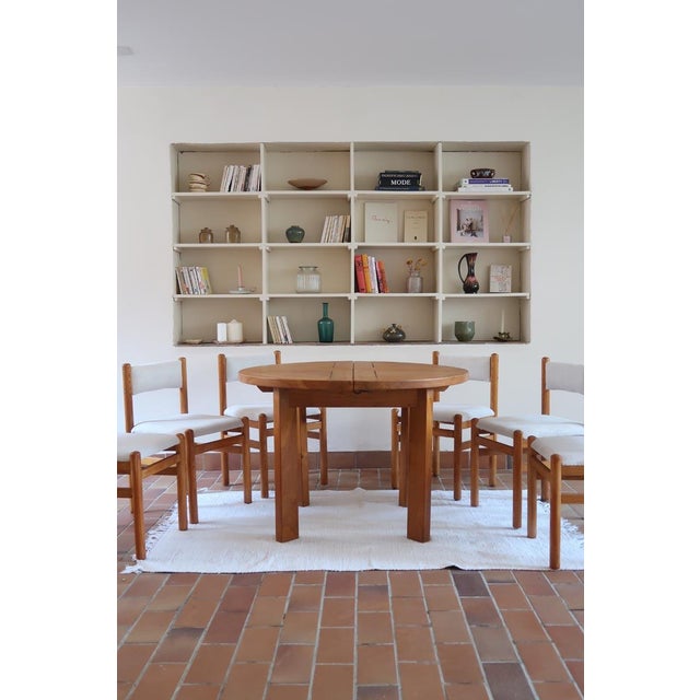 A round dining table in solid elm, attributed to Maison Regain and made in France in the 1980s. The top is built from...