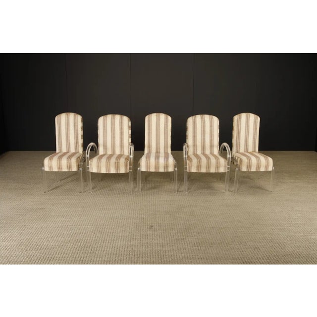 A striking set of five waterfall-style dining chairs in thick, curved Lucite, attributed to Hill Manufacturing, with...
