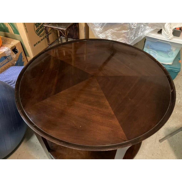 Attached are pics of a Bill Sofield designed two tier walnut round table manufactured by Baker furniture. The table is 36...