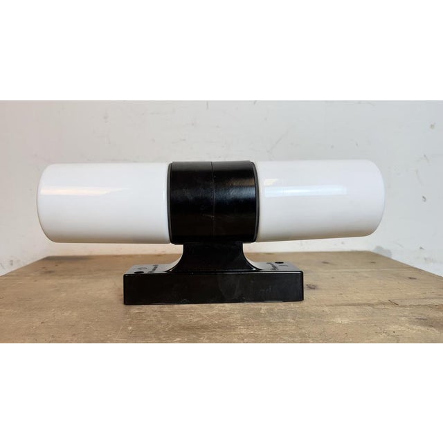 Vintage industrial dark brown bakelite wall lamp made in former Czechoslovakia during the 1960s. It features a bakelite...