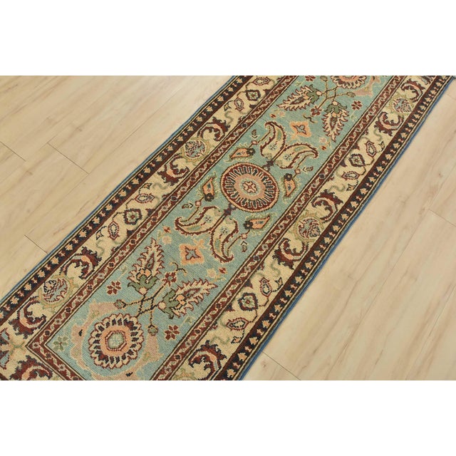 A traditional Caucasian Kazak runner hand-knotted with fine wool on a cotton foundation. This rug features botanical...