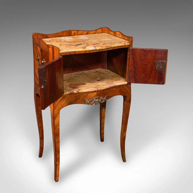 This is an exquisite antique side table. An Italian, kingwood and marble bedside nightstand dating to the late Victorian...
