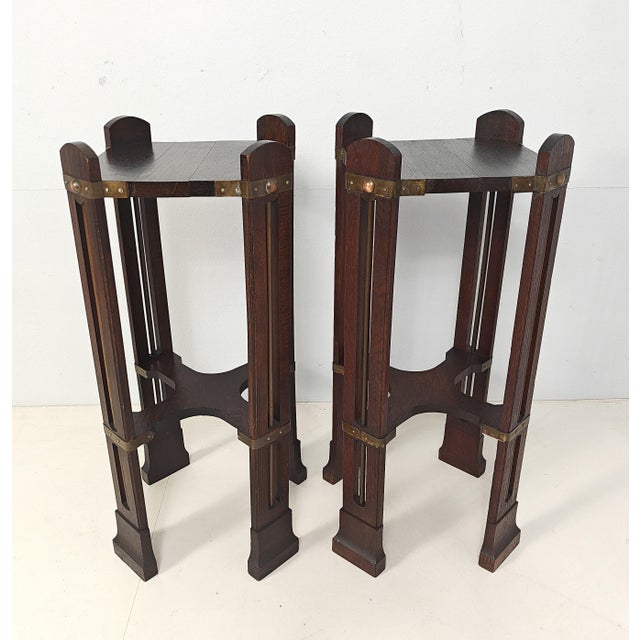 Pair of side tables, in stained oak, designed and crafted around 1900, standing on four legs, with brass rods and brass...