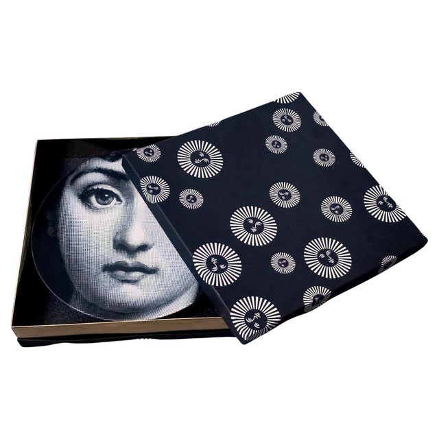 The face of the opera singer Lina Cavalieri, Piero Fornasetti's muse, embellishes this decorative porcelain wall plate....