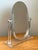 This mid-20th century vanity mirror is crafted from clear Lucite in an elegantly arched silhouette, a hallmark of the...