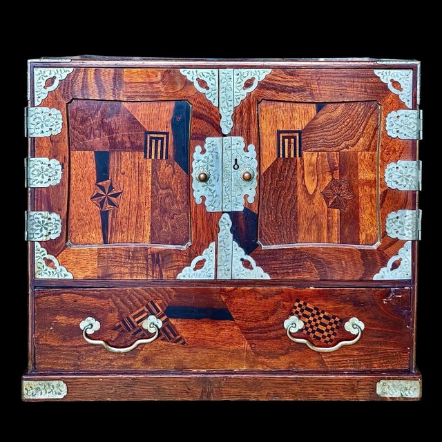 This vintage Japanese inlaid parquetry table cabinet, also known as a tansu chest, beautifully showcases the traditional...