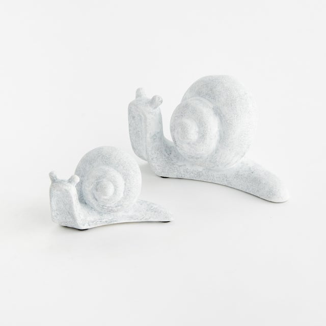 This sweet little duo of modern snail sculptures is made of concrete and finished in aWhitewash. A charming accent for the...