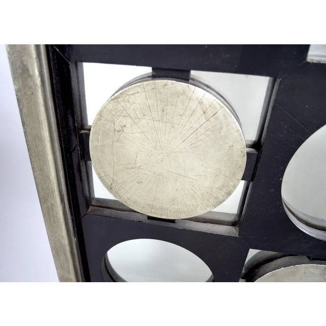 Black and silver circles and dots alternate with mirror to form a checkerboard mirror surface. Very decorative modernist...