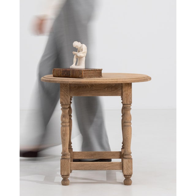 A 20th century French side table crafted in oak, featuring a compact square top supported by a solid frame. The design is...