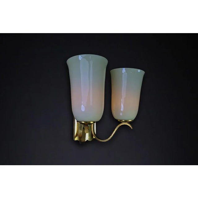 This elegant mid-century wall sconce from the 1950s showcases exquisite german craftsmanship. It features gracefully...